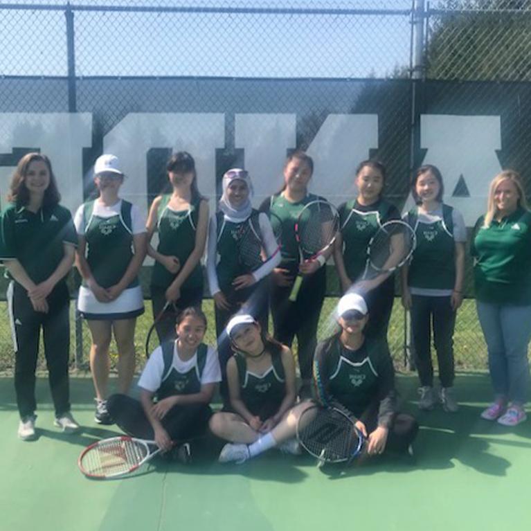 The Chase Collegiate girls' tennis team poses for a group photo on the court.